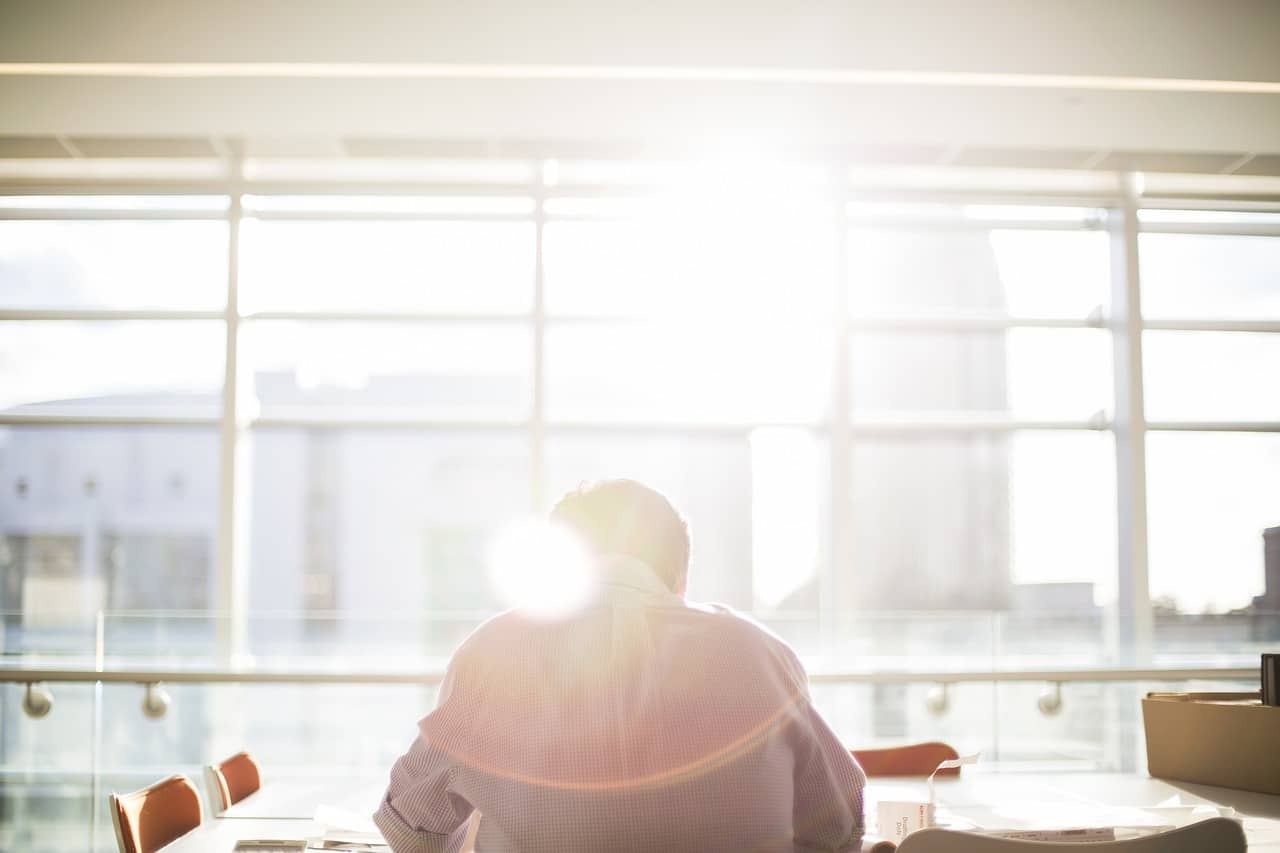 Personadi spalle che sta studiando davanti ad una vetrata