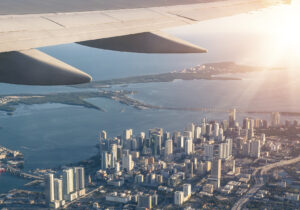 Ala di un aereo in volo con vista della città