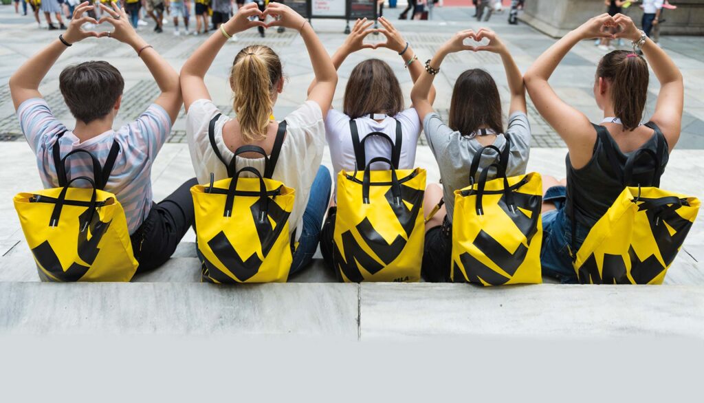 Cinque studenti seduti con lo zaino MLA