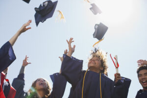 Studenti laureati che lanciano in aria il tocco accademico