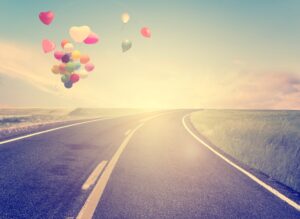 strada con palloncini a forma di cuore in volo