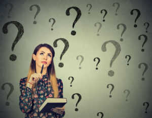 ragazza dubbiosa con punti interrogativi alle spalle