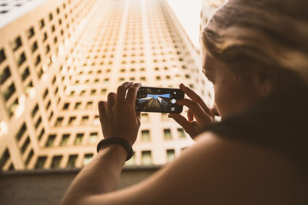ragazza che fotografa un grattacielo