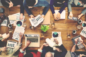 Tavolo ripreso dall'alto con persone che lavorano al pc